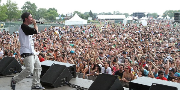 Aerial view of Governors Ball Music Festival at Flushing Meadows-Corona Park with crowds, stages, and NYC skyline.